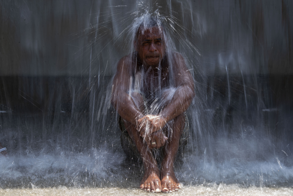 A man cools off in a water fountain at Madureira Park amid a heat wave in Rio de Janeiro, Brazil, Wednesday, Nov. 15, 2023. (AP Photo/Bruna Prado)