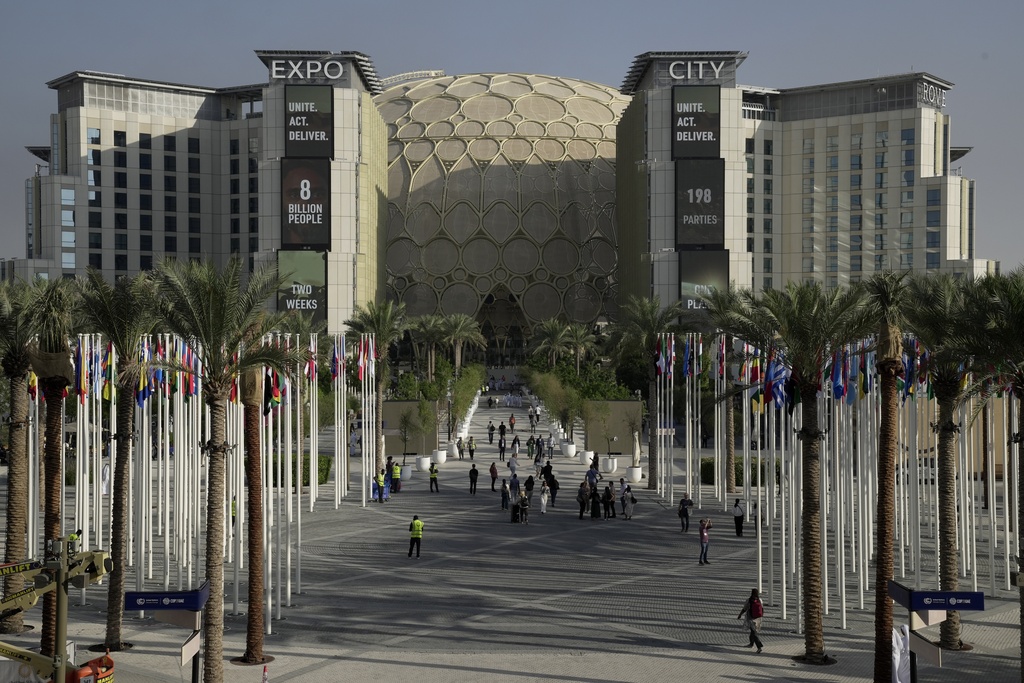 People walk the venue for the COP28 U.N. Climate Summit with the Al Wasl Dome in the background at Expo City, Wednesday, Nov. 29, 2023, in Dubai, United Arab Emirates. (AP Photo/Joshua A. Bickel)
