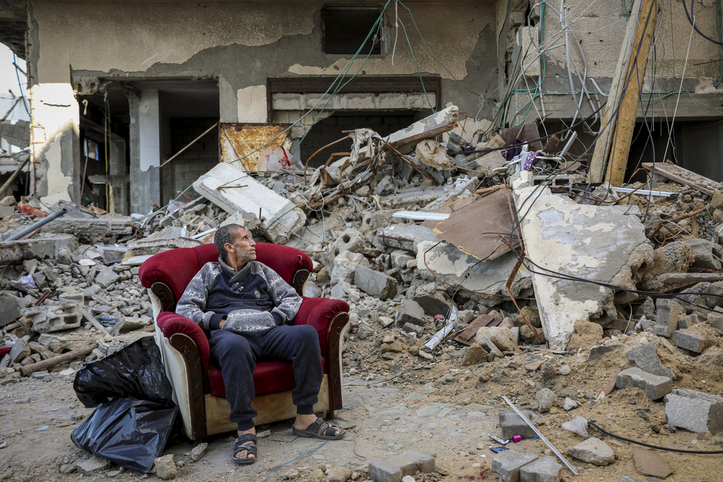 A Palestinian man sits in an armchair outside a destroyed building in Gaza City on Wednesday, Nov. 29, 2023, the sixth day of the temporary cease-fire between Hamas and Israel. International mediators on Wednesday worked to extend the truce in Gaza, encouraging Hamas militants to keep freeing hostages in exchange for the release of Palestinian prisoners and further relief from Israel's air and ground offensive. (AP Photo/Mohammed Hajjar)