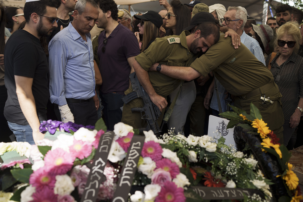 Relatives and friends of Israeli Col. Asaf Hamami mourn during his funeral at the Kiryat Shaul military cemetery, in Tel Aviv, Israel, Monday, Dec. 4, 2023. Hamami, the commander of the Gaza Division's Southern Brigade, was killed on Oct. 7, in the unprecedented, multi-front attack on Israel by the militant group Hamas that rules Gaza. and his remains are being held in the Gaza Strip, the Israeli military said. (AP Photo/Leo Correa)