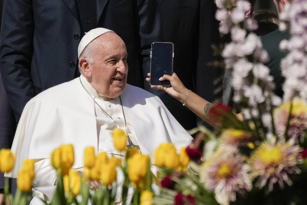 FILE - A woman holds a phone as Pope Francis leaves after his weekly general audience in St. Peter's Square, at the Vatican, Wednesday, April 12, 2023. Pope Francis called Thursday for an international treaty to ensure artificial intelligence is developed and used ethically, arguing that the risks of technology lacking human values of compassion, mercy, morality and forgiveness are too great. (AP Photo/Alessandra Tarantino, File)