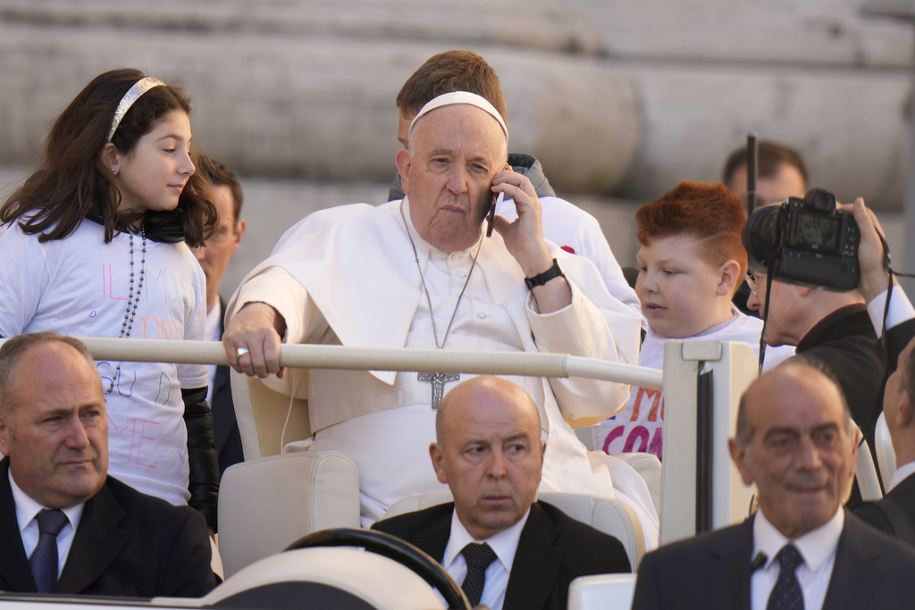 FILE - Pope Francis talks on a phone as he arrives for his weekly general audience in St. Peter's Square at The Vatican, Wednesday, March 15, 2023. Pope Francis called Thursday for an international treaty to ensure artificial intelligence is developed and used ethically, arguing that the risks of technology lacking human values of compassion, mercy, morality and forgiveness are too great. (AP Photo/Alessandra Tarantino, File)