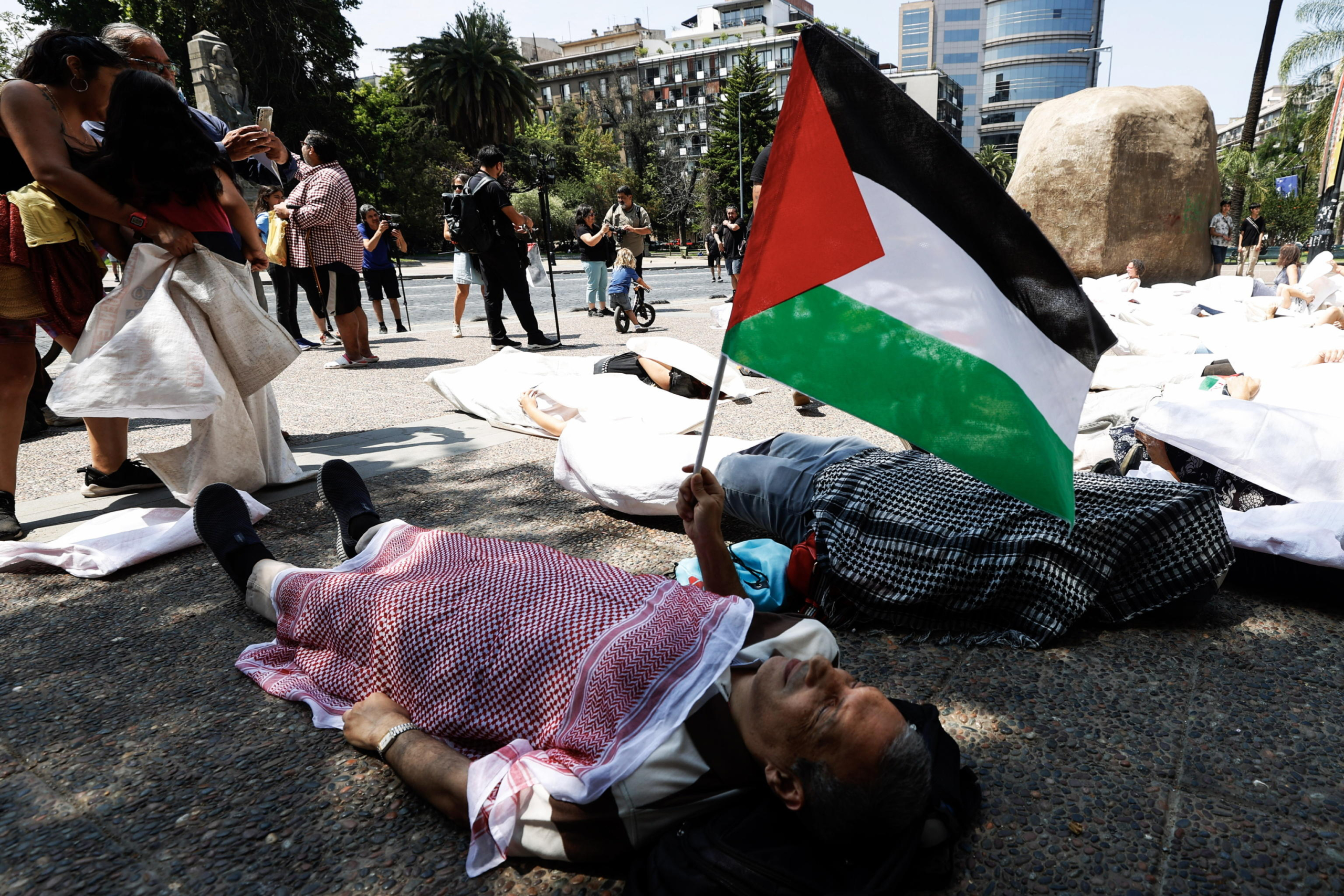 epa11061386 A demonstrator lying down holds a Palestinian flag during a symbolic demonstration in support of the Palestinian people, marking 90 days of the ongoing Israeli-Hamas conflict in Gaza, in front of the National Museum of Fine Arts building in Santiago, Chile, 06 January 2024. Thousands of Israelis and Palestinians have died since the militant group Hamas launched an unprecedented attack on Israel from the Gaza Strip on 07 October, and the Israeli strikes on the Palestinian enclave which followed it.  Foto Ansa, EPA/ELVIS GONZALEZ