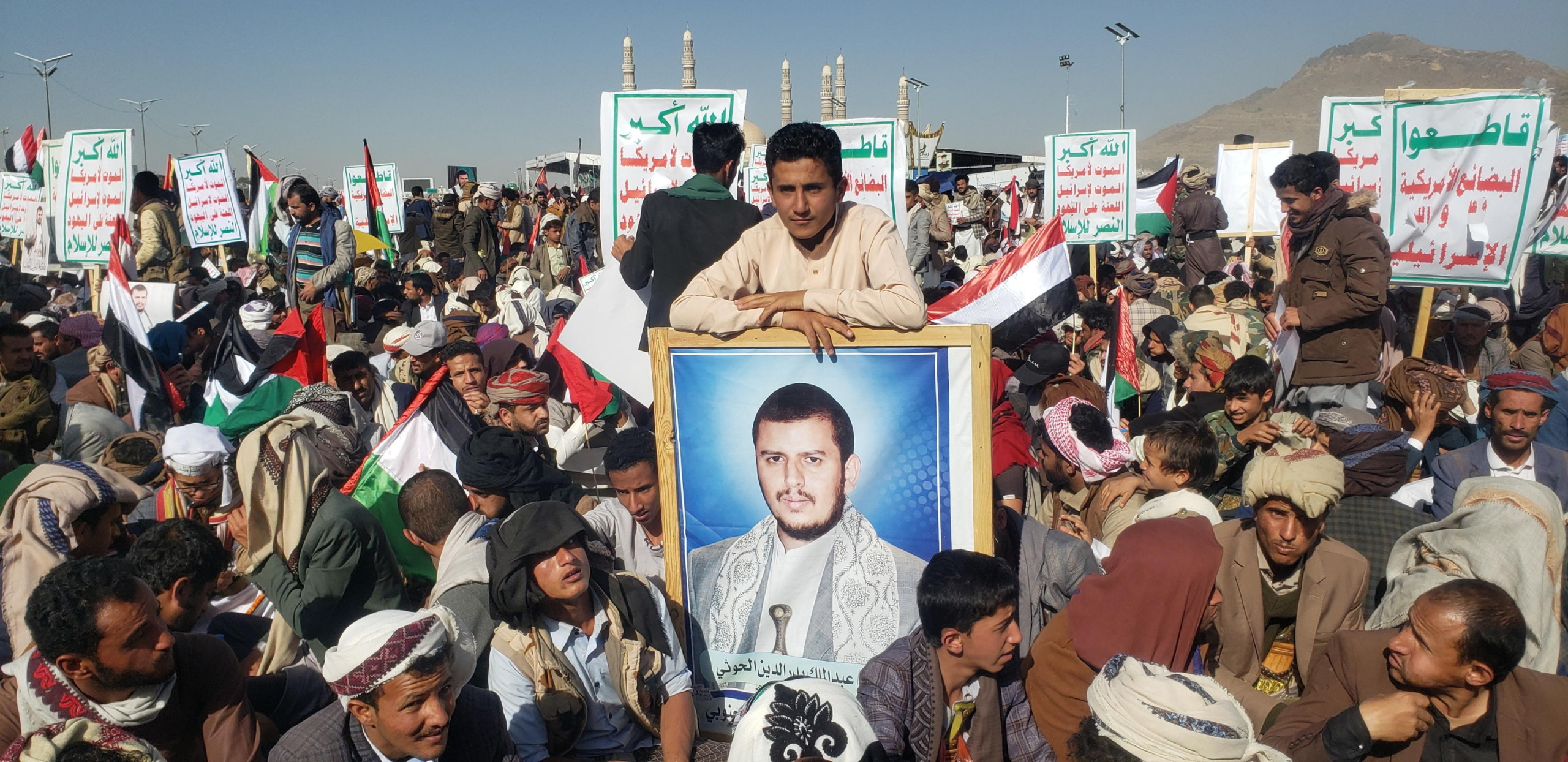 epa11071353 A person holds a photo of Houthi leader Abdul-Malik al-Houthi during a protest against a multinational operation to safeguard Red Sea shipping following Houthi attacks and the subsequent US and UK airstrikes on Houthis military sites, in Sanaa, Yemen, 12 January 2024.  EPA/YAHYA ARHAB via ANSA