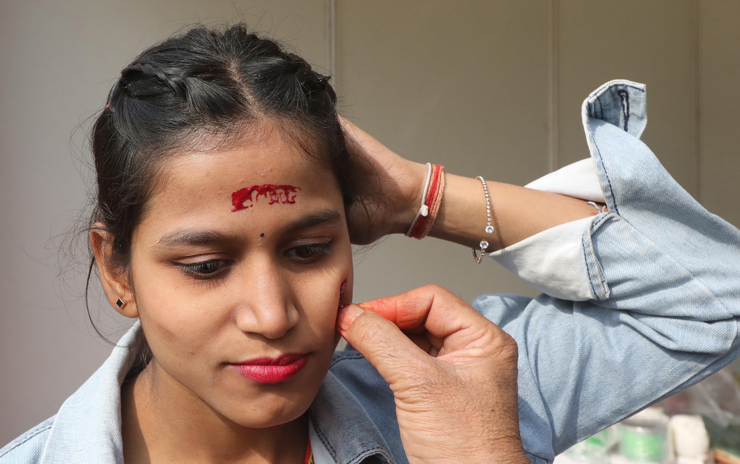 epaselect epa11087207 A Hindu devotee gets the name of Lord Ram inked on her face at the India International Ramayana Festival in New Delhi, India, 18 January 2024. Indian Council of Cultural Relations (ICCR) organized a five-day long festival emphasizing the enduring relevance and universality of the Ramayana ahead of the Pran Pratistha ceremony, or the inauguration ceremony of the Lord Ram temple in Ayodhya, that is scheduled for 22 January 2024. Pran Pratistha is the act which transforms an idol into a deity, giving it the capacity to accept prayers. The Indian prime minister will perform the Pran Pratishtha ceremony on the inauguration day.  EPA/HARISH TYAGI