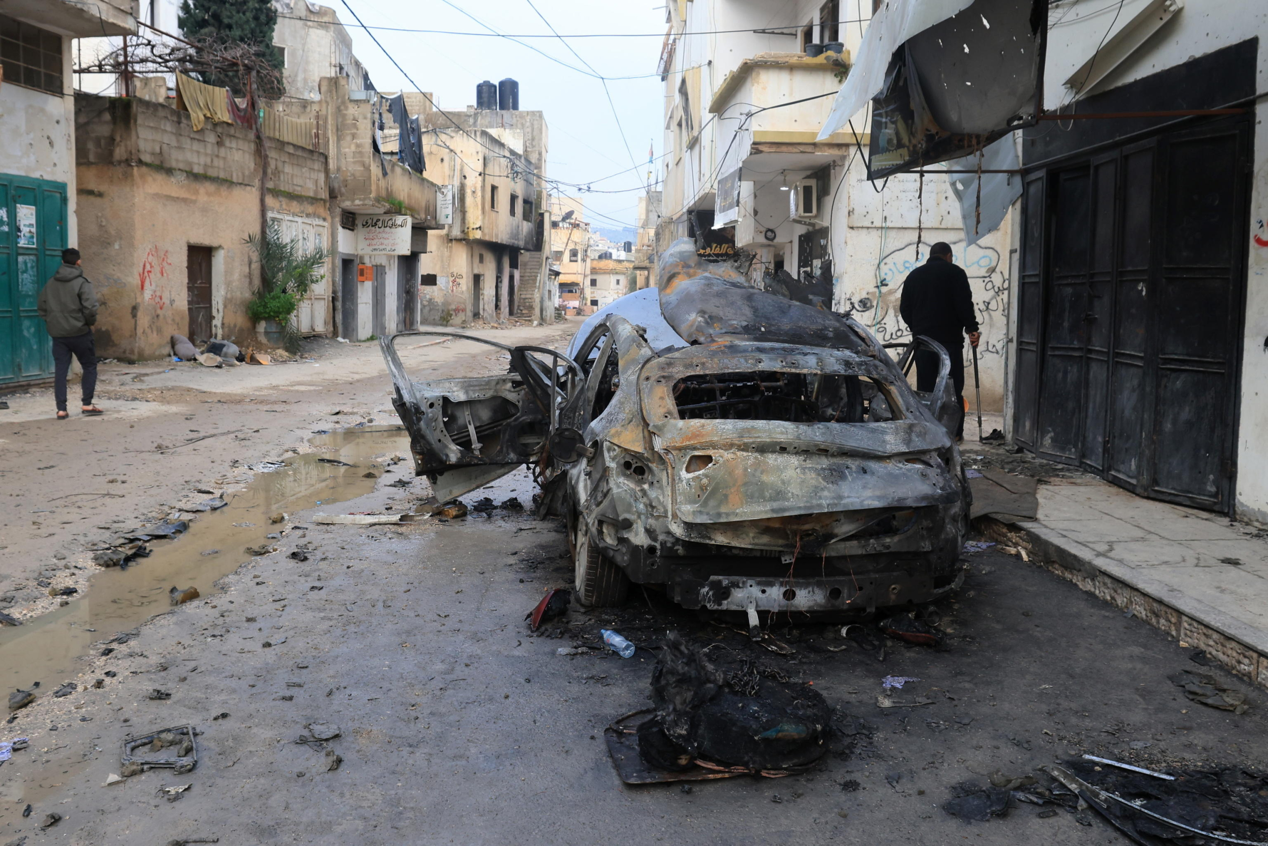 epa11174115 A destroyed car sits on a street following strikes by the Israeli army in Jenin, West Bank, 23 February 2024. Two Palestinians were killed and 14 wounded during an overnight Israeil airstrike in Jenin's refugee camp, according to the Palestinian health ministry. More than 29,400 Palestinians and over 1,300 Israelis have been killed, according to the Palestinian Health Ministry and the Israel Defense Forces (IDF), since Hamas militants launched an attack against Israel from the Gaza Strip on 07 October 2023, and the Israeli operations in Gaza and the West Bank which followed it.  EPA/ALAA BADARNEH