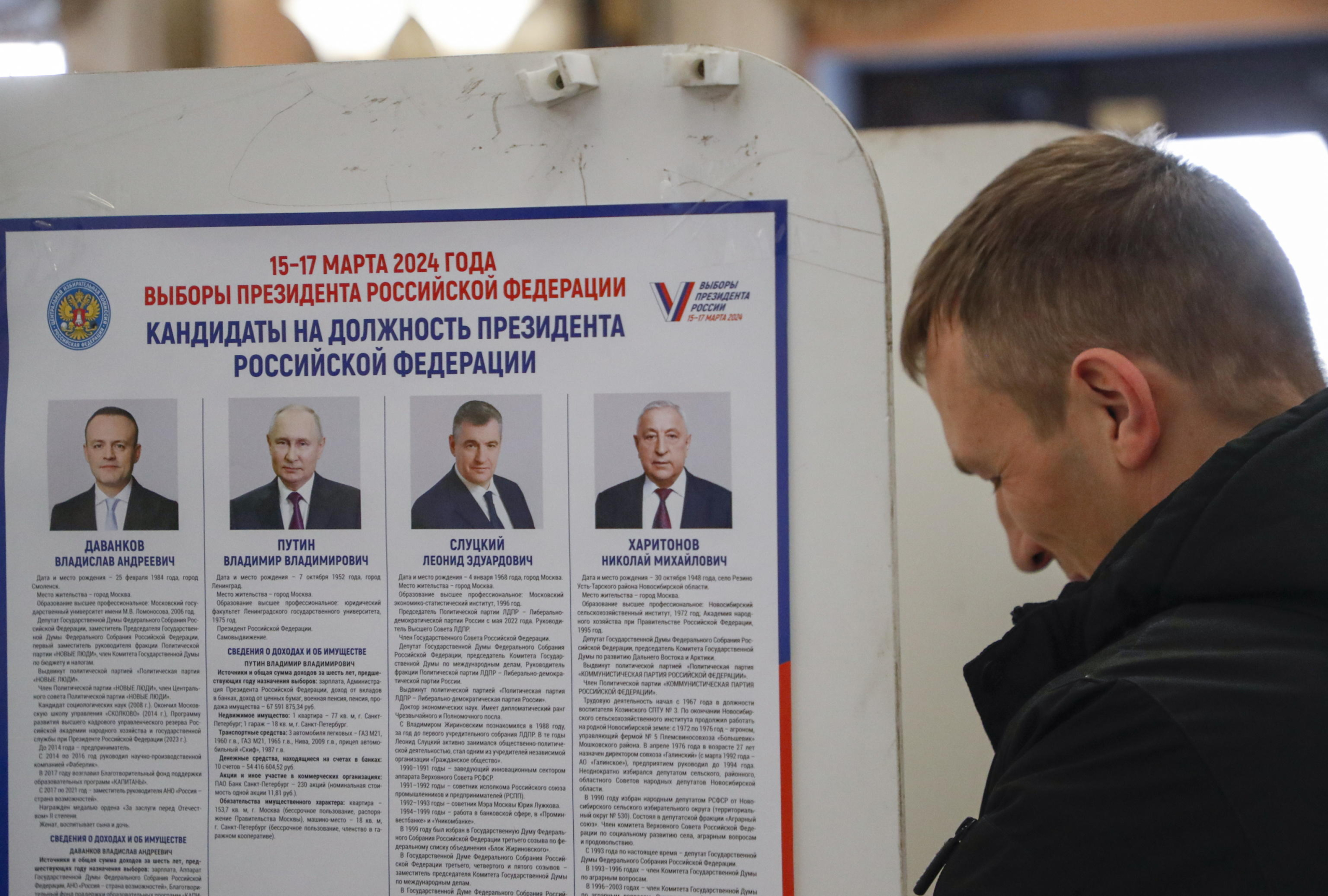 epa11221731 A Russian man examines an information poster with pictures of the candidates for Russian presidential elections during presidential elections in Moscow, Russia, 15 March 2024. The Federation Council has scheduled presidential elections for 17 March 2024. Voting will last three days, from 15 to 17 March. Four candidates registered by the Central Election Commission of the Russian Federation are vying for the post of head of state: Leonid Slutsky, Nikolai Kharitonov, Vladislav Davankov, and Vladimir Putin.  EPA/MAXIM SHIPENKOV