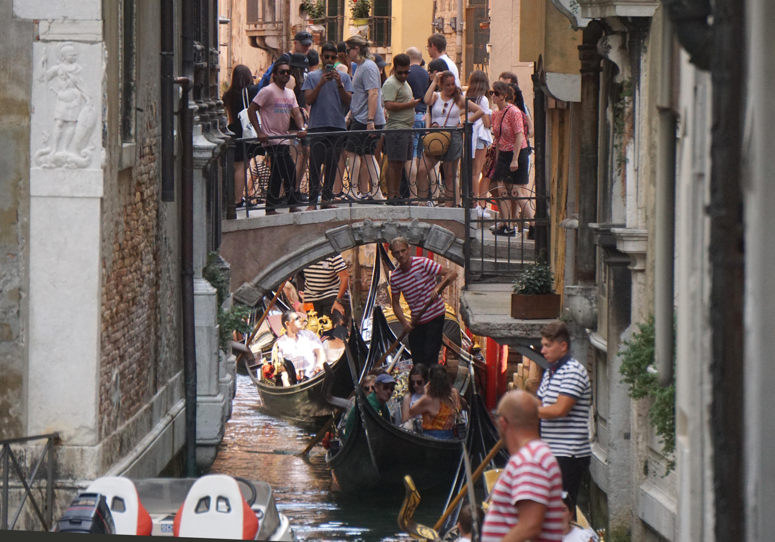 Gondole e turisti su un canale interno del centro storico di Venezia, 13 agosto 2022. 
ANSA/ANDREA MEROLA