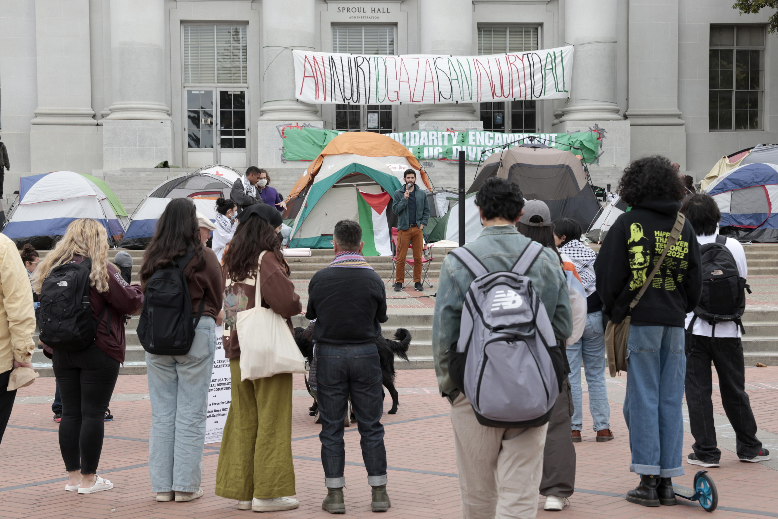 epa11296677 Students listen to a speaker at the University of California Berkeley (UC Berkeley) as students occupy an encampment of tents in front of Sproul Hall, the campus administration building, as they protest UC Berkeleys investment ties to Israel in Berkeley, California, USA, 23 April 2024. More than 34,000 Palestinians and over 1,450 Israelis have been killed, according to the Palestinian Health Ministry and the Israel Defense Forces (IDF), since Hamas militants launched an attack against Israel from the Gaza Strip on 07 October 2023, and the Israeli operations in Gaza and the West Bank which followed it.  EPA/JOHN G. MABANGLO