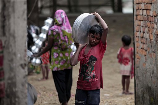 Un ragazzino trasporta pezzi di alluminio in Bangladesh