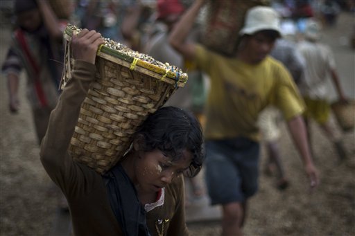 Una bambina trasporta pietre da una cava in Myanmar