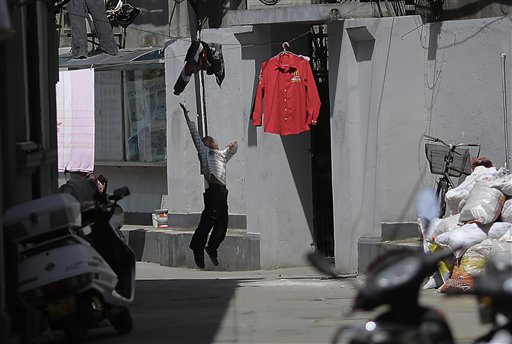 Un bimbo salta per raggiungere i panni stesi a Shanghai