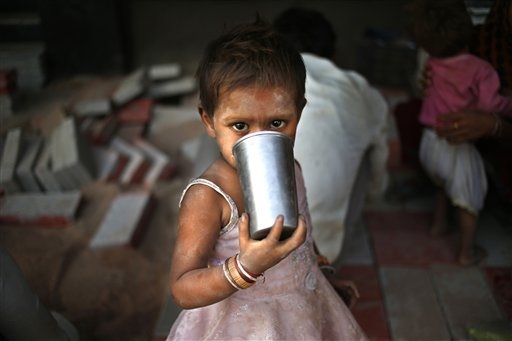 Grande caldo in India. Bambina beve