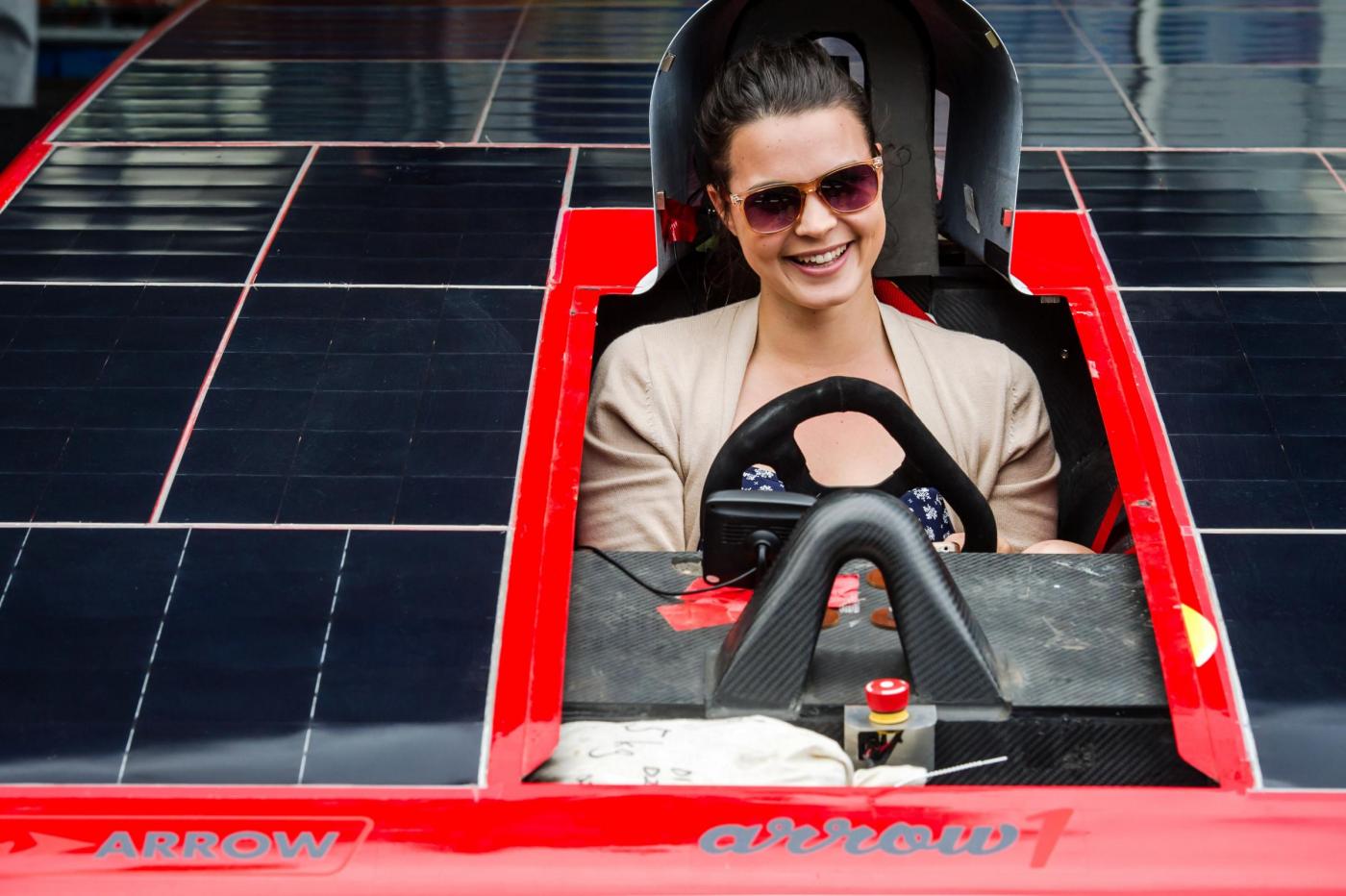 Una ragazza siede su un prototipo di auto solare