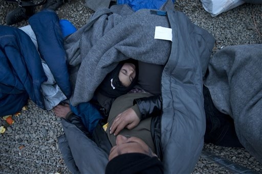 Un papà si dispera con in braccio la sua bambina nel campo profughi di Idomeni per non essere riuscito a passare la frontiera macedone