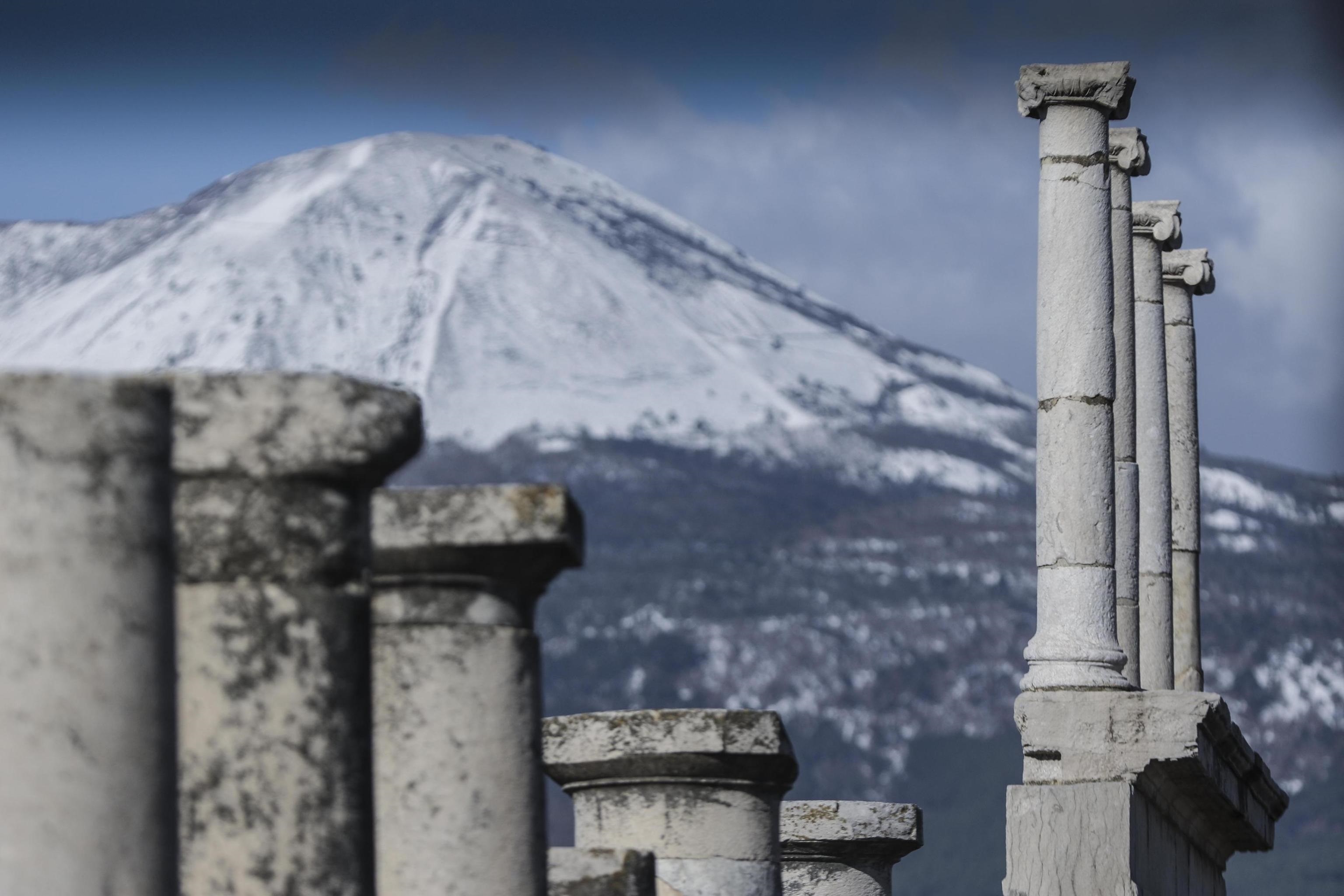 The snow-covered peak of Mount Vesuvius volcano seen from the archaeological excavations of Pompeii in Naples, southern Italy, 06 January 2017. Large areas of Italy are affected by strong winds, snowfall and low temperatures. ANSA/ CESARE ABBATE
