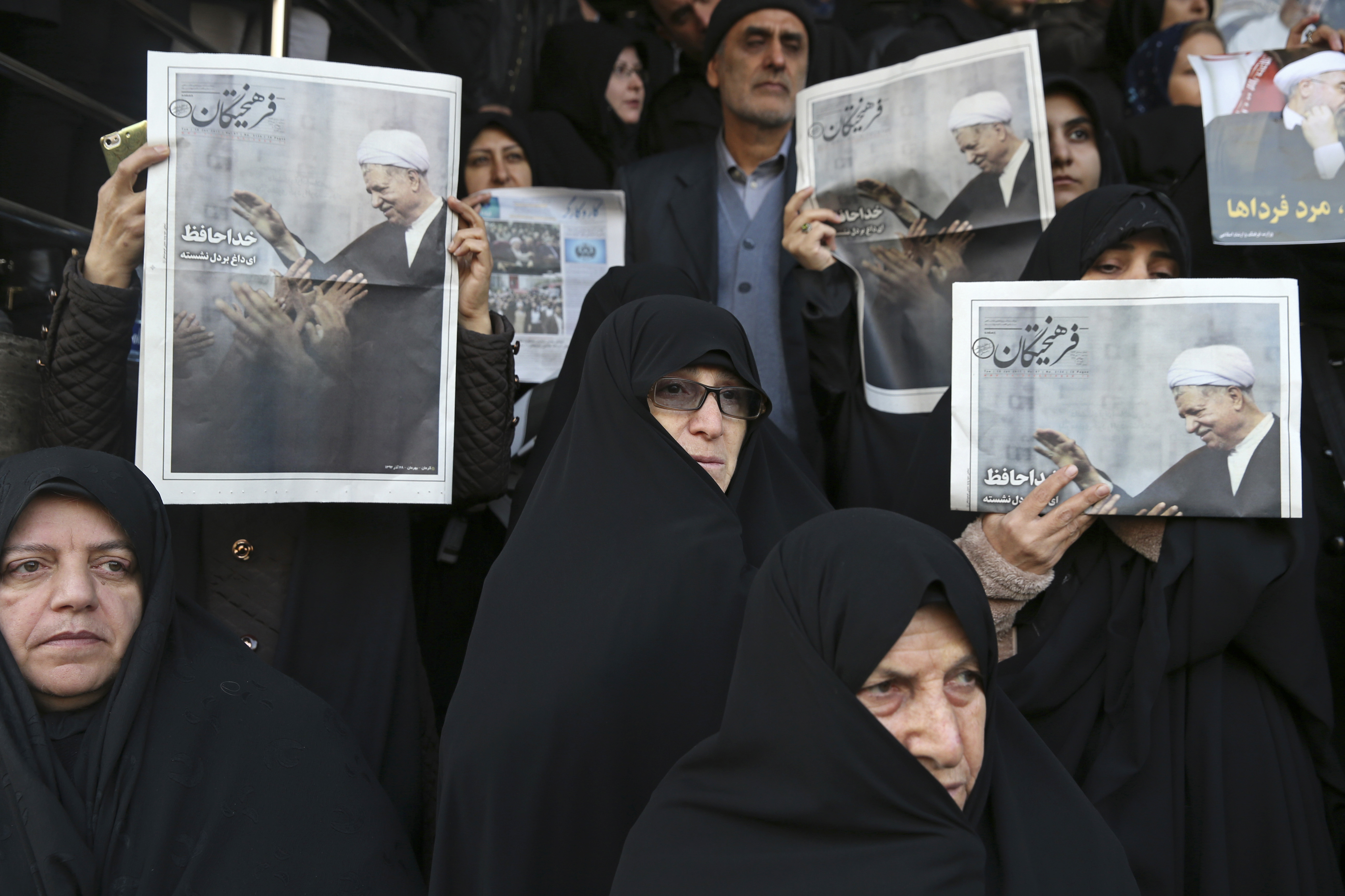 Mourners hold copies of a special edition of Farhikhtegan newspaper showing former Iranian President Akbar Hashemi Rafsanjani during his funeral in Tehran, Iran, Tuesday, Jan. 10, 2017. Hundreds of thousands of mourners have flooded the streets of Tehran, beating their chests and wailing in grief for Rafsanjani, who died over the weekend at the age of 82. The crowds have filled main thoroughfares of the capital as top government and clerical officials held a funeral service at Tehran University. (AP Photo/Vahid Salemi)