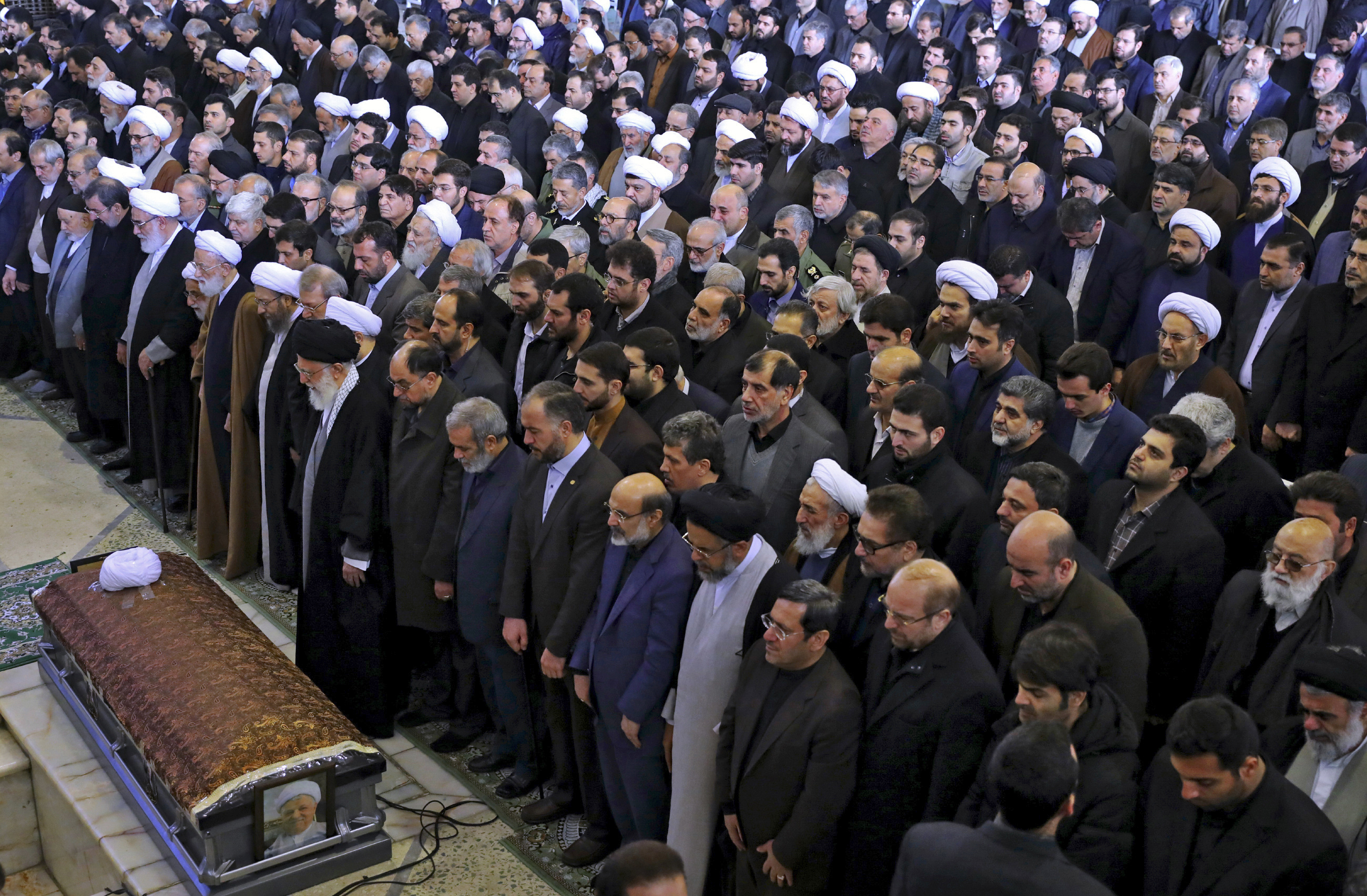 In this picture released by an official website of the office of the Iranian supreme leader, Supreme Leader Ayatollah Ali Khamenei, left foreground, leads a prayer over the casket of former Iranian  President Akbar Hashemi Rafsanjani, with top government and clerical officials, at the Tehran University campus in Tehran, Iran, Tuesday, Jan. 10, 2017. Hundreds of thousands of mourners have flooded the streets of Tehran, beating their chests and wailing in grief for Rafsanjani, who died over the weekend at the age of 82. The crowds have filled main thoroughfares of the capital as top government and clerical officials held a funeral service at Tehran University. (Office of the Iranian Supreme Leader via AP)
