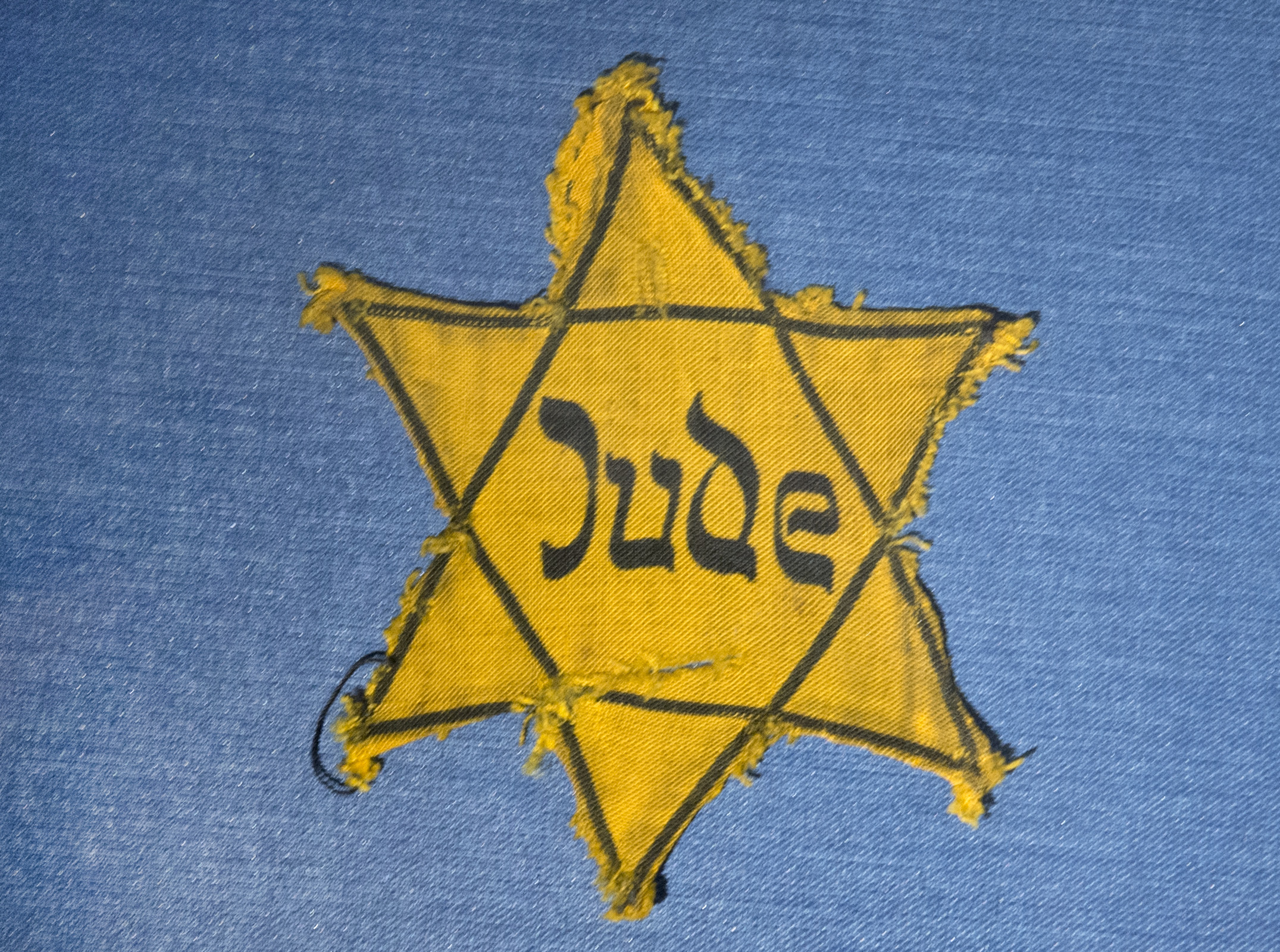 The Yellow Star badge of Heinz-Joachim Aris (Dresden 1941) reading 'Jew' is displayed  in a showcase during a press preview in the new special exhibition 'Shoes of the Dead - Dresden and the Shoah' at the Military History Museum in Dresden in Dresden, eastern Germany, Wednesday, Jan. 22, 2014.  The exhibition    is in remembrance of  Jewish citizens who were transported from  Dresdens train stations to the Nazi concentration camps. The exhibition starts on Jan. 23, 2014 and lasts until March 25, 2014.. (AP Photo/Jens Meyer)