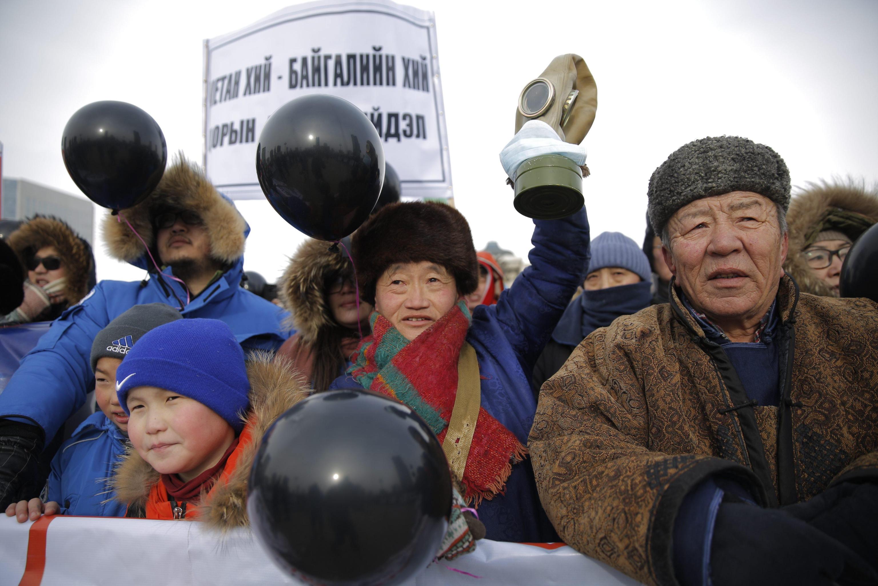 epa05756146 Mongolian protesters carry black balloons and placards as they march to demand government action to stop heavy air pollution during a rally at the Sukhbaatar Square in Ulaanbaatar, Mongolia, 28 January 2017. About 5,000 protesters participated in the rally to demand major action from the government to combat heavy air pollution plaguing the country's capital.  EPA/DAVAANYAM DELGERJARGAL