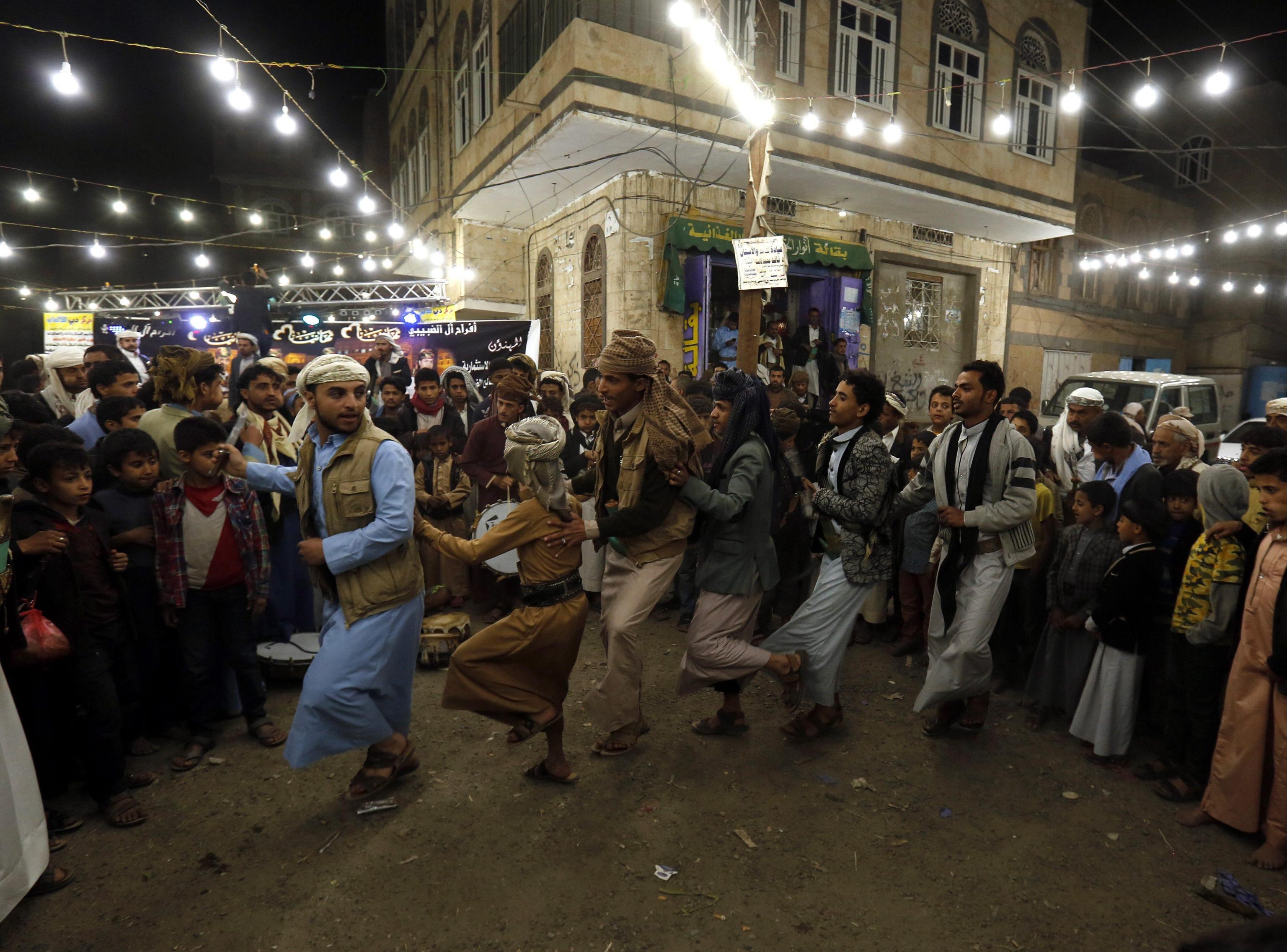 epa05775348 A picture made available on 06 February 2017 shows Yemenis performing traditional dances during a wedding ceremony in Sana'a, Yemen, 05 February 2017. Yemen has unique traditions that gives a special character to its weddings, which are costly and lavish, especially considering the country's low per capita income and its 22-month ongoing conflict. Upon strict Muslim traditions practiced in Yemen, the wedding parties are held without intermixing; the brides and grooms are kept in separate halls.  EPA/YAHYA ARHAB