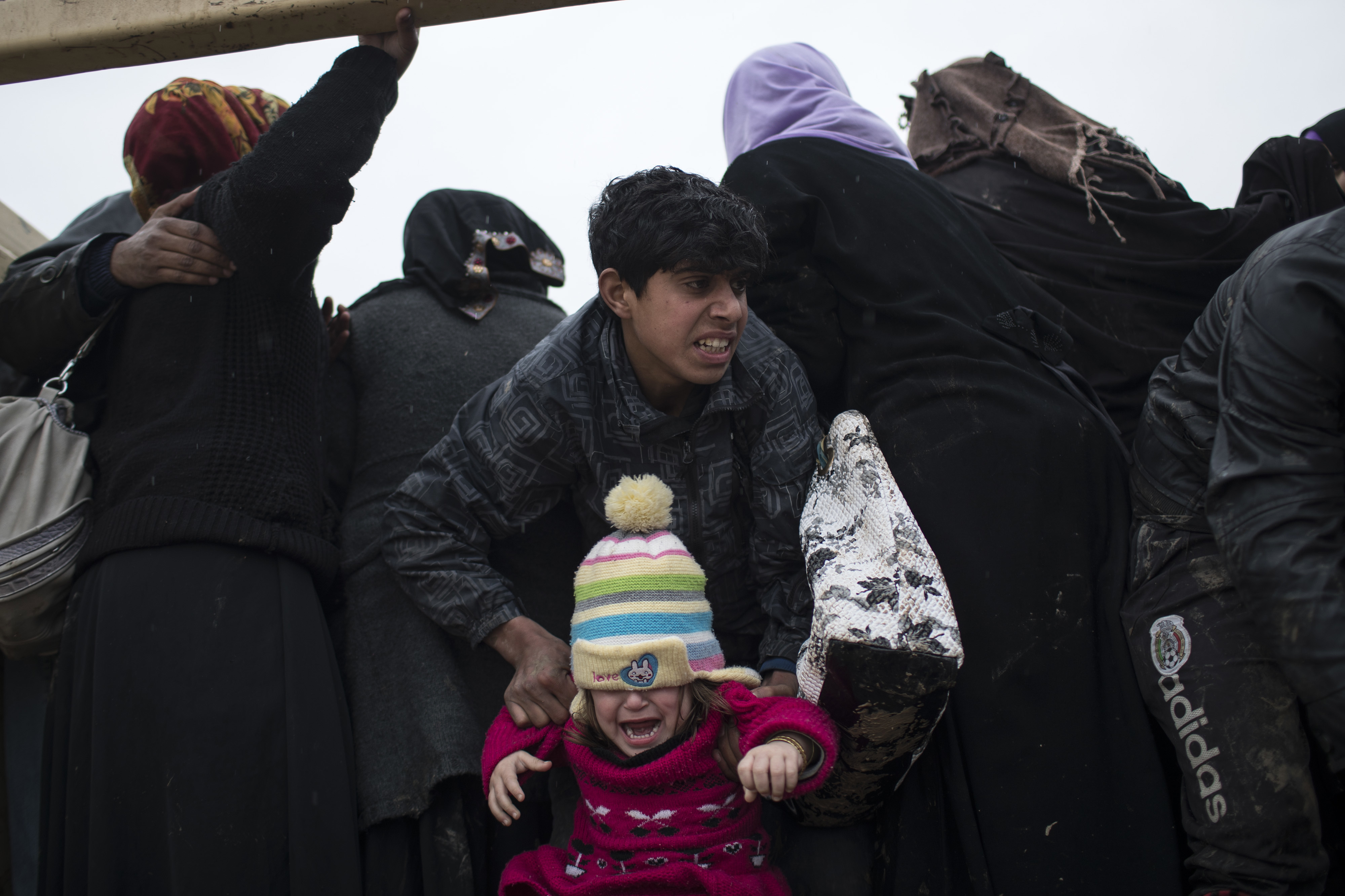 Displaced Iraqis, fleeing fighting between Iraqi security forces and Islamic State militants, are board a truck before being taken to a camp on the western side of Mosul, Iraq, Thursday, March 23, 2017. (AP Photo/Felipe Dana)