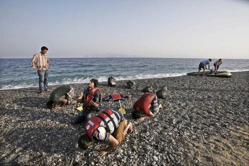 Immigrati pakistani pregano dopo l'arrivo a Kos in Grecia