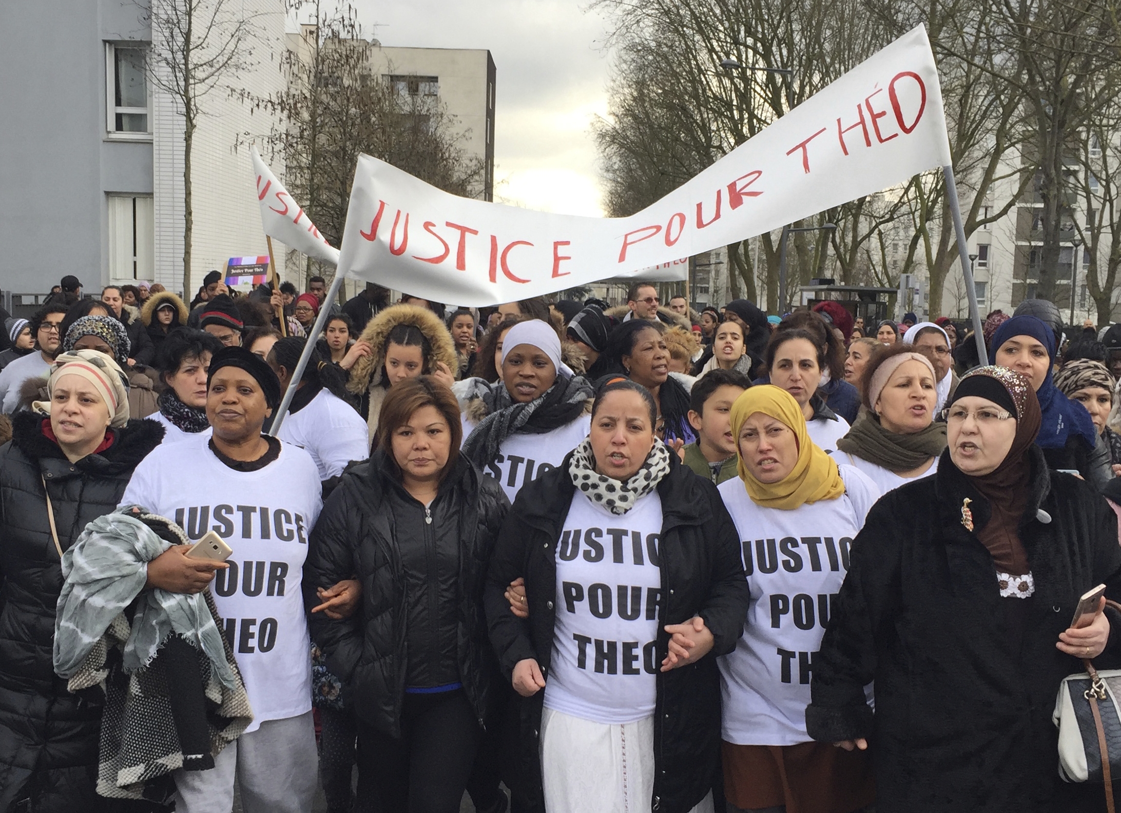 People march in the streets of Aulnay-sous-Bois, north of Paris, France, holding a sign reading "Justice for Theo" during a protest, a day after a French police officer was charged with the rape of a youth, Monday, Feb. 6, 2017. One French police officer has been charged with raping a 22-year-old man and three others have been charged with assault after an identity check degenerated last week in the Paris suburb of Aulnay-sous-Bois. (AP Photo/Milos Krivokapic)