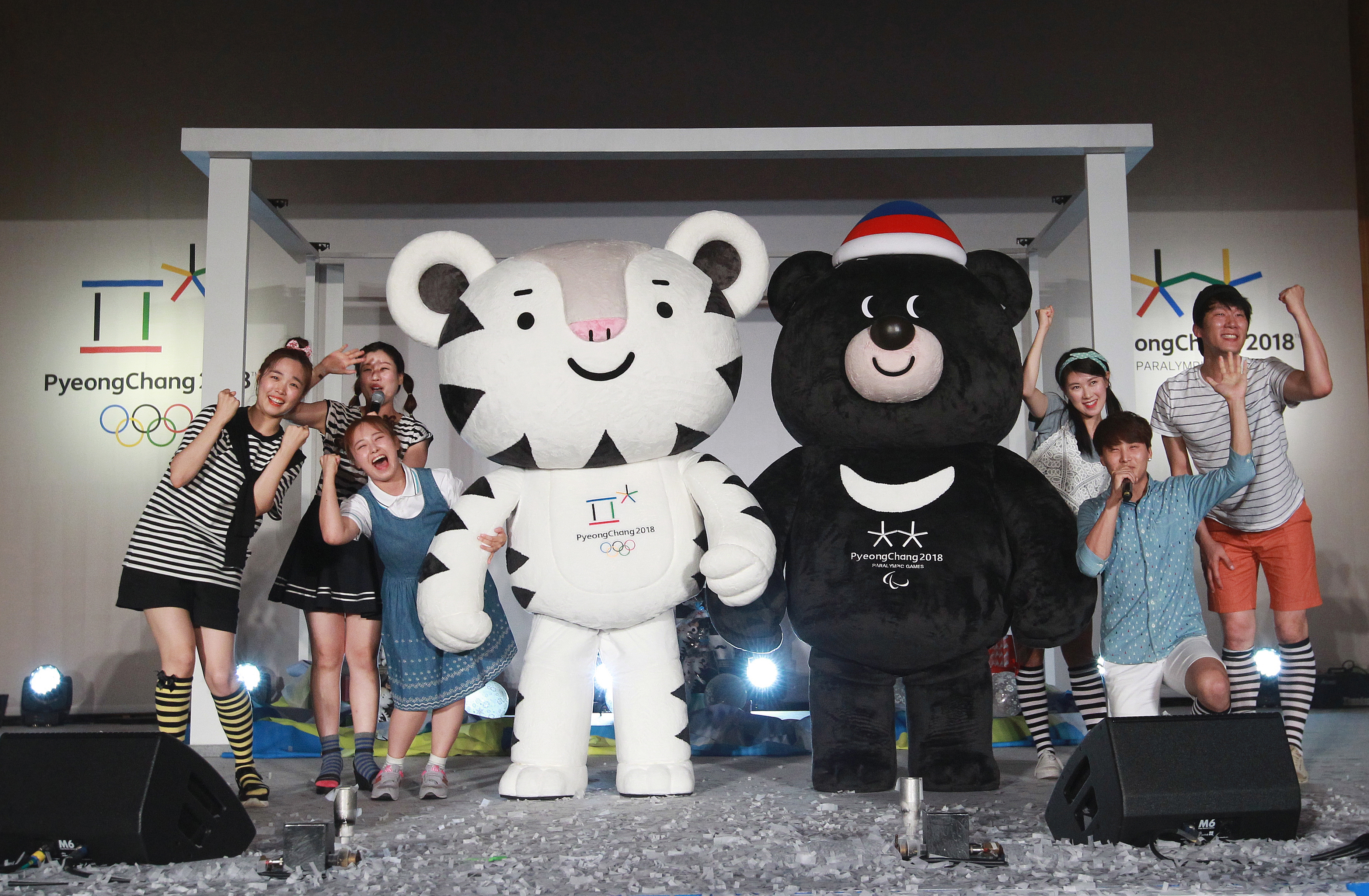 Volunteers pose with the official mascots for the 2018 PyeongChang Olympic, named Soohorang, left, and Paralympic Winter Games, named Bandabi, during their launching ceremony at Hoeng Gye Elementary School in Pyeongchang, South Korea, Monday, July 18, 2016. The PyeongChang Organizing Committee for the 2018 Olympic and Paralympic Winter Games announced on Monday it nationwide mascot promotion tour . (AP Photo/Ahn Young-joon)