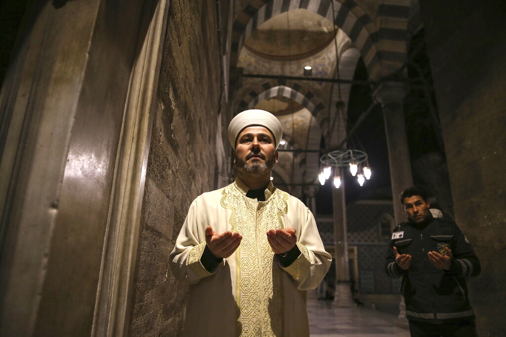 Imam of Eyup Sultan Mosque, Hasan Tok holdd a prayer for coronavirus in Istanbul, Friday, April 3, 2020. After the fifth and final call to prayer of the day in Muslim Turkey, imams around the country have been asked to perform an additional prayer asking for God’s mercy and protection during the novel coronavirus pandemic.  Calls echoed across the city of Istanbul, Turkey’s largest, thousands of people have been infected with the virus and where hundreds have already died. (AP Photo/Emrah Gurel)