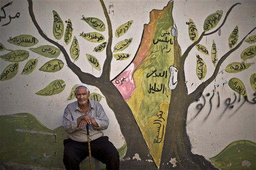 Nel campo profughi di Jenin (in Giordania), il rifugiato palestinese Ali Abu Jabal, 73 anni, siede davanti al muro dipinto che raffigura la Terra Santa. L'uomo aveva 7 anni quando lui e i suoi genitori furono costretti a lasciare la loro casa nella città israeliana di Haifa. Da allora sogna di tornare nella sua terra. (AP Photo/Muhammed Muheisen)