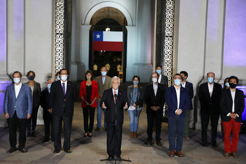Chile's President Sebastian Pinera, center, speaks at La Moneda presidential palace on the day Chileans voted in a referendum to decide whether the country should replace its 40-year-old constitution, written during the dictatorship of Gen. Augusto Pinochet, in Santiago, Chile, Sunday, Oct. 25, 2020. (Dragomir Yankovic/Aton Chile via AP)