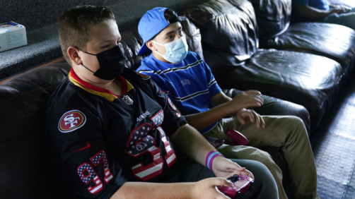Fans play video games inside the Game Truck before a preseason NFL football game between the Los Angeles Chargers and the San Francisco 49ers Sunday, Aug. 22, 2021, in Inglewood, Calif. (AP Photo/Ashley Landis)