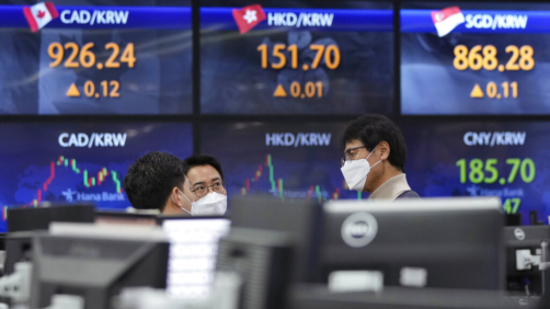 Currency traders talk each other at the foreign exchange dealing room of the KEB Hana Bank headquarters in Seoul, South Korea, Friday, Dec. 17, 2021. Shares fell in Asia on Friday after technology companies led Wall Street benchmarks lower as investors weighed the implications of higher interest rates, surging coronavirus cases and tensions between Beijing and Washington. (AP Photo/Ahn Young-joon)