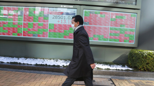 A man walks by an electronic stock board of a securities firm in Tokyo, Friday, Jan. 7, 2022.  Asian markets are mostly higher after more declines in big technology stocks pulled major indexes lower on Wall Street. Tokyo and Taiwan declined but other regional markets advanced. U.S. futures also were higher.(AP Photo/Koji Sasahara)