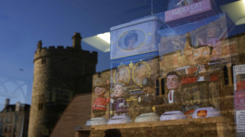 Souvenirs are displayed for sale in the window of a shop with a reflection of Windsor Castle, in Windsor, England, where Prince Andrew residence is nearby in the grounds of Windsor Great Park, Thursday, Jan. 13, 2022. A judge has — for now — refused to dismiss a lawsuit against Britain's Prince Andrew by an American woman who says he sexually abused her when she was 17. Stressing Wednesday that he wasn't ruling on the truth of the allegations, U.S. District Judge Lewis A. Kaplan rejected an argument by Andrew's lawyers that Virginia Giuffre's lawsuit should be thrown out at an early stage because of an old legal settlement she had with Jeffrey Epstein, the financier she claims set up sexual encounters with the prince. (AP Photo/Matt Dunham)