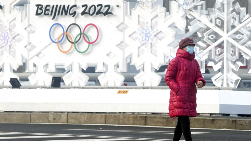 A woman walks near the Olympic Park at the 2022 Winter Olympics, Tuesday, Jan. 25, 2022, in Beijing, China. (AP Photo/David J. Phillip)