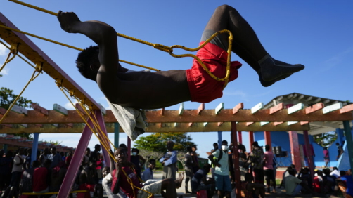 A Haitian migrant swings at a tourist campground in Sierra Morena, in the Villa Clara province of Cuba, Wednesday, May 25, 2022. A vessel carrying more than 800 Haitians trying to reach the United States wound up instead on the coast of central Cuba, government news media said Wednesday. (AP Photo Ramon Espinosa)