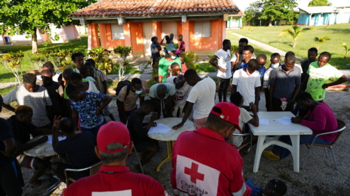 Cuban Red Cross workers attend to Haitian migrants at a tourist campground in Sierra Morena, in the Villa Clara province of Cuba, Wednesday, May 25, 2022. A vessel carrying more than 800 Haitians trying to reach the United States wound up instead on the coast of central Cuba, government news media said Wednesday. (AP Photo Ramon Espinosa)