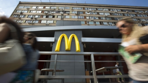 People walk past the oldest of Moscow's McDonald's outlets which was opened on Jan. 31, 1990, and closed on Thursday, Aug. 21, 2014. Russian news agencies reported Thursday that the country's food safety agency will conduct checks on McDonald's restaurants in the Urals following food safety complaints, a day after four branches of the chain were shuttered in Moscow. (AP Photo/Alexander Zemlianichenko)