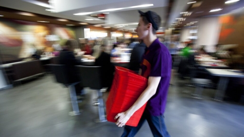 Worker carries trays in the McDonald's restaurant situated at the Pushkinskaya square in Moscow, Russia, Thursday, April 11, 2013. This is the first McDonald's restaurant in Russia, opened at January 31, 1990. (AP Photo/Pavel Golovkin)