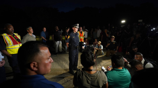 San Antonio Police Chief William McManus, center, briefs media and others at the scene where dozens of people have been found dead and multiple others were taken to hospitals with heat-related illnesses after a semitrailer containing suspected migrants was found, Monday, June 27, 2022, in San Antonio. (AP Photo/Eric Gay)