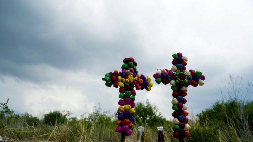 Crosses and candles stand as a make-shift memorial at the site where officials found dozens of people dead in an abandoned semitrailer containing suspected migrants, Tuesday, June 28, 2022, in San Antonio. (AP Photo/Eric Gay)