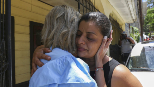 Karen Caballero, the mother of Fernando Redondo Caballero and Alejandro Andino Caballero who died near San Antonio, Texas, after being discovered in a hot trailer full of migrants being smuggled into the US, is comforted during an impromptu conference at their home in Las Vegas, Honduras, Wednesday, June 29, 2022. Caballero's sons were among the bodies of 51 people discovered in what is believed to be the nation's deadliest smuggling episode on the U.S.-Mexico border. (AP Photo/Delmer Martinez)