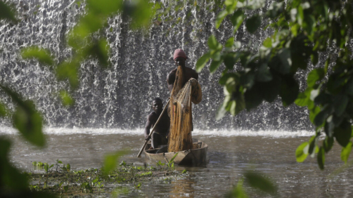 Fishermen paddle a canoe near a dam that sources the sacred Osun River in Esa-Odo, Nigeria, on Saturday, May 28, 2022. The river is under constant threat from pollution from waste disposal and other human activity — especially the dozens of illegal gold miners across Osun state whose runoff is filling the river with toxic metals. (AP Photo/Sunday Alamba)