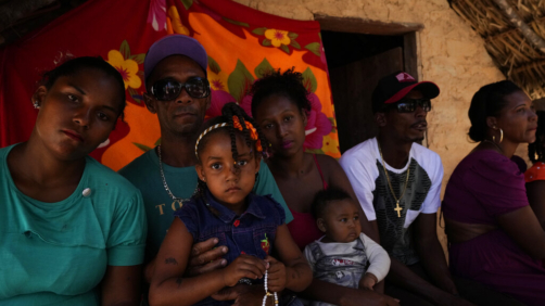 A family with their baptized daughter poses for photos in front of their home in the Kalunga quilombo, during the culmination of the week-long pilgrimage and celebration for the patron saint 