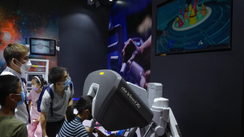 A visitor tries out a Chinese-made robotic arm used for surgeon during the World Robot Conference at the Yichuang International Conference and Exhibition Centre in Beijing, Thursday, Aug. 18, 2022. (AP Photo/Andy Wong)