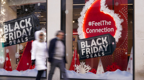 People walk past a Black Friday sign outside a retail shop in Oxford Street, in London, Friday, Nov. 25, 2022. (AP Photo/Alberto Pezzali)