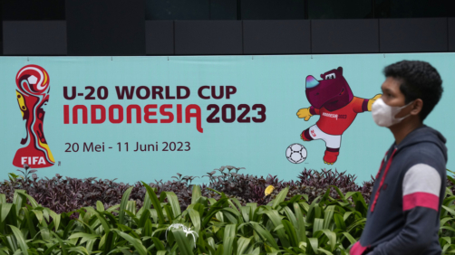 A man walks past a banner of FIFA U-20 World Cup outside the building housing the office of Indonesian Soccer Association, PSSI, in Jakarta, Indonesia, Thursday, March 30, 2023. Indonesia was stripped of hosting rights for the Under-20 World Cup on Wednesday only eight weeks before the start of the tournament amid political turmoil regarding Israel's participation. (AP Photo/Dita Alangkara)