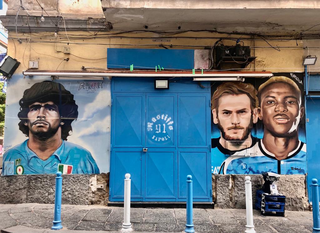 Murales di Maradona, a sinistra, e di Victor Osimhen e Khvicha Kvaratskhelia a destra, a Forcella, Napoli, foto di Sara Fornaro